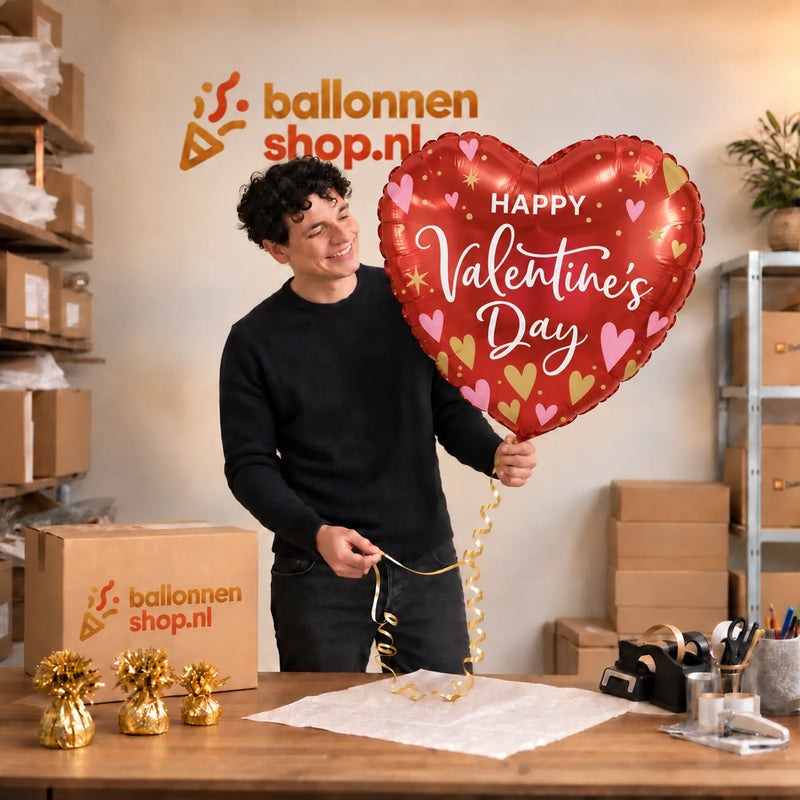 Jesse houdt de Mega Happy Valentines Day Hart Ballon vast in de warme inpakruimte van Ballonnenshop.nl.