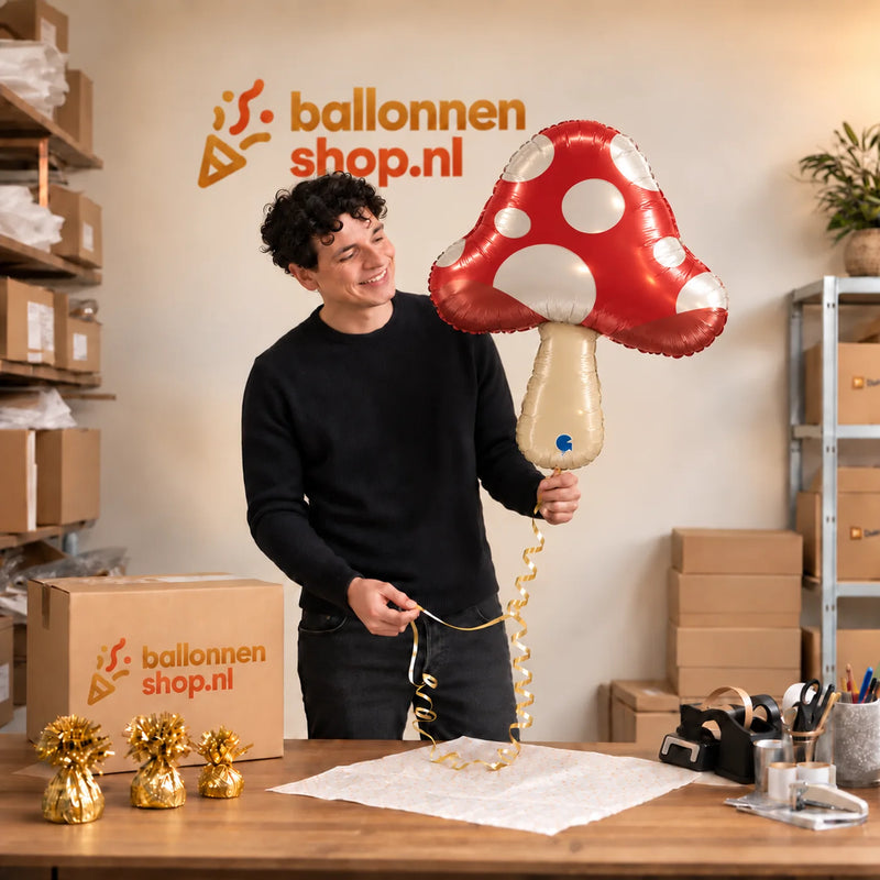 Jesse houdt de Paddenstoel Helium Ballon vast in de warme inpakruimte van Ballonnenshop.nl.