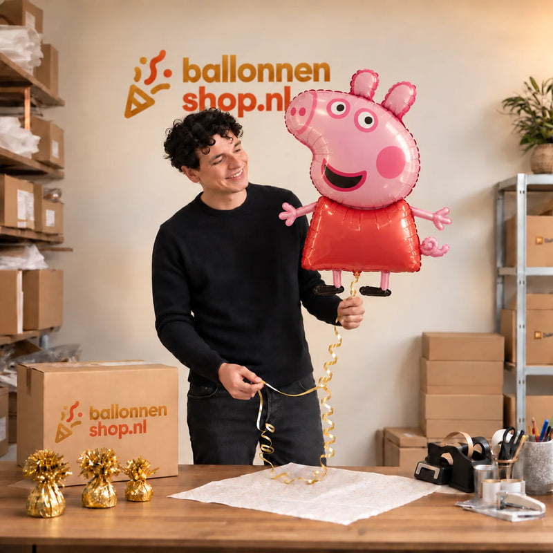 Jesse houdt de Peppa Pig Helium XL Ballon vast in de warme inpakruimte van Ballonnenshop.nl.