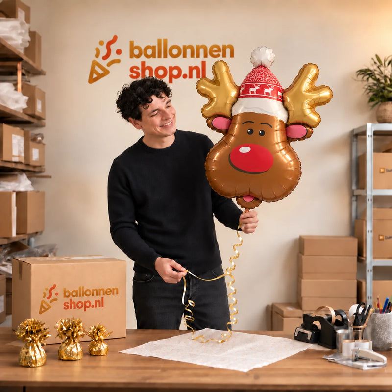 Jesse houdt de Rendier Helium Ballon vast in de warme inpakruimte van Ballonnenshop.nl.