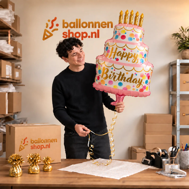 Jesse houdt de Satijnen Verjaardagstaart XL vast in de warme inpakruimte van Ballonnenshop.nl.