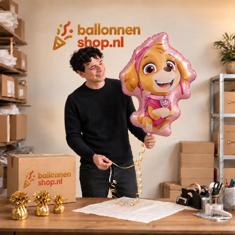 Jesse houdt de Skye Paw Patrol Helium XL Ballon vast in de warme inpakruimte van Ballonnenshop.nl.