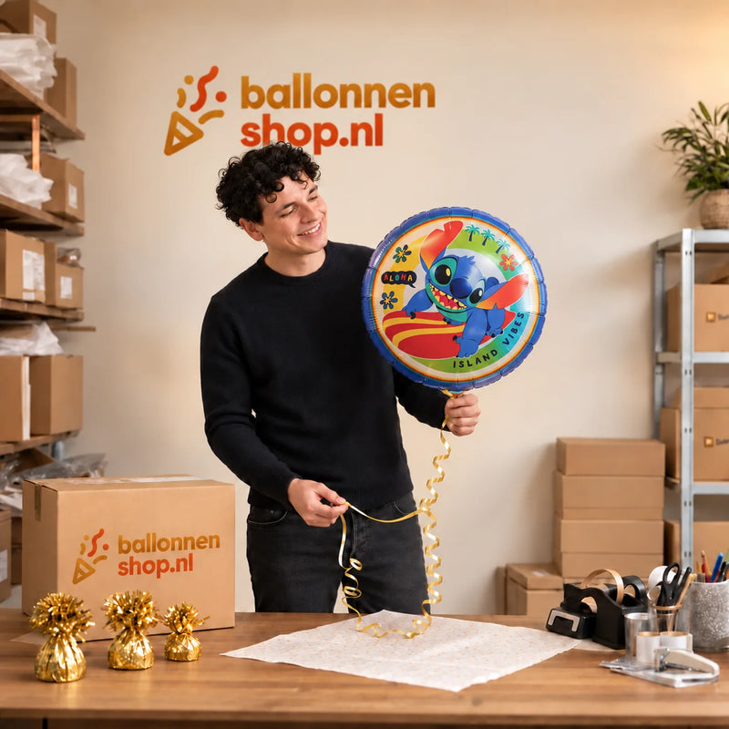 Jesse houdt de Stitch Op Surfboard Helium Ballon vast in de warme inpakruimte van Ballonnenshop.nl.