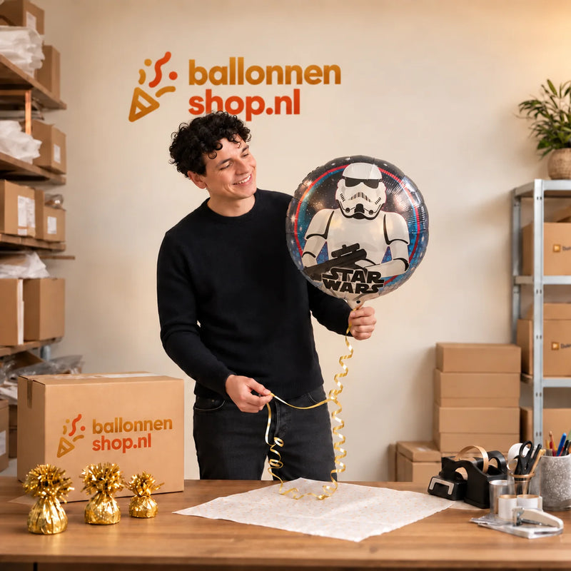 Jesse houdt de Stormtrooper Helium Ballon vast in de warme inpakruimte van Ballonnenshop.nl.