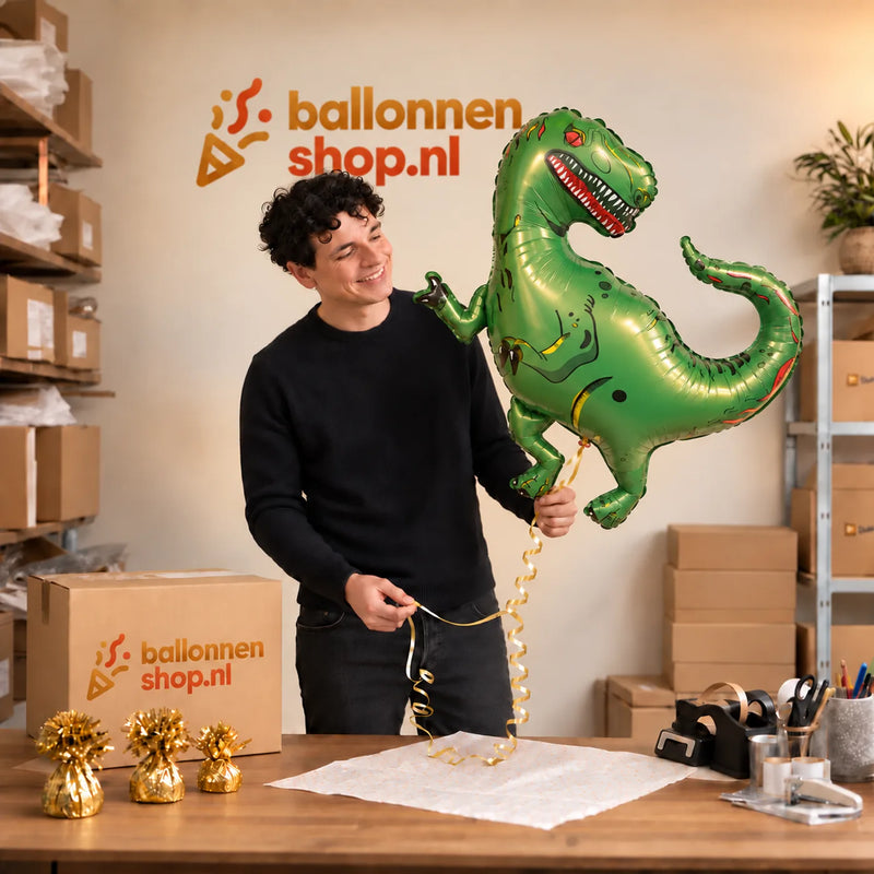 Jesse houdt de Tyrannosaurus Rex Dino XL Ballon vast in de warme inpakruimte van Ballonnenshop.nl.