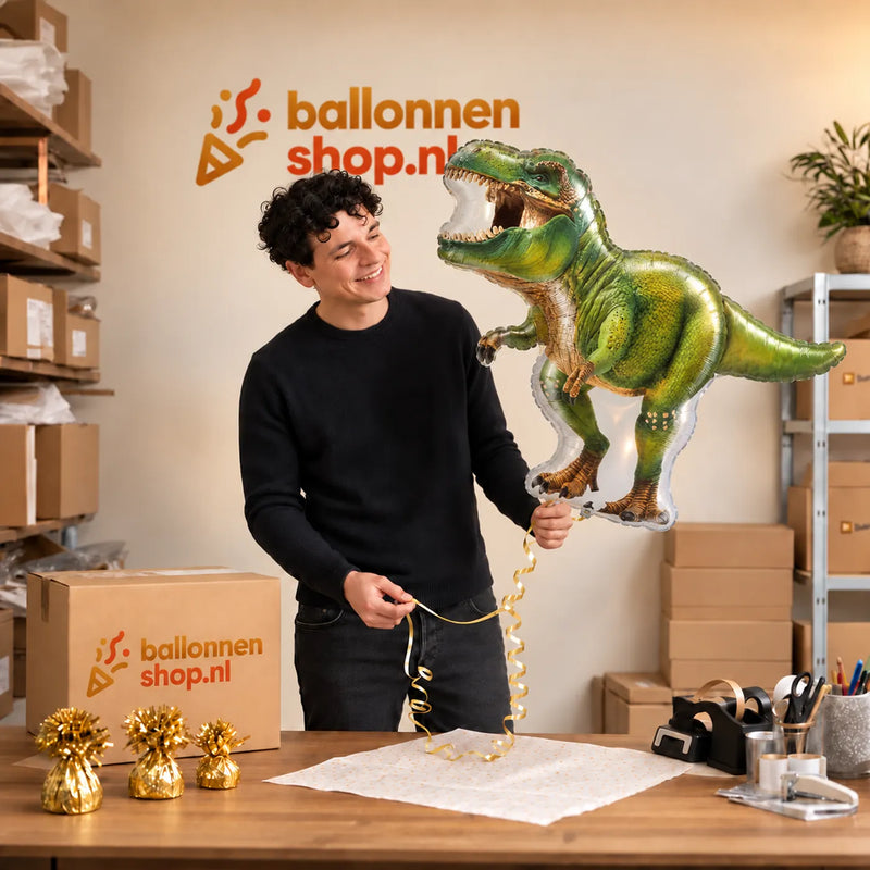 Jesse houdt de Tyrannosaurus Rex Dino XL Ballon vast in de warme inpakruimte van Ballonnenshop.nl.