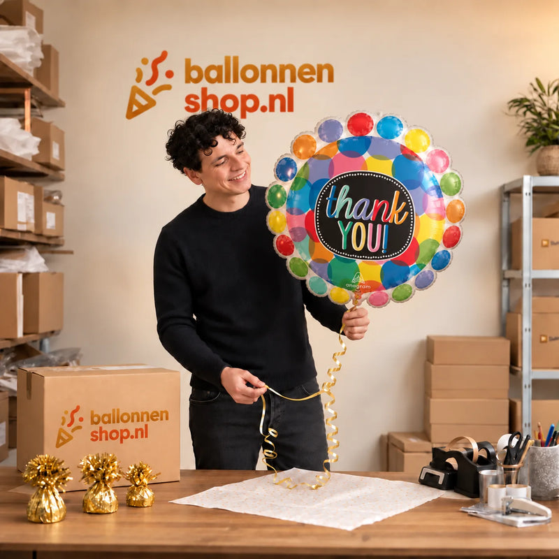 Jesse houdt de Thank You Helium Ballon vast in de warme inpakruimte van Ballonnenshop.nl.