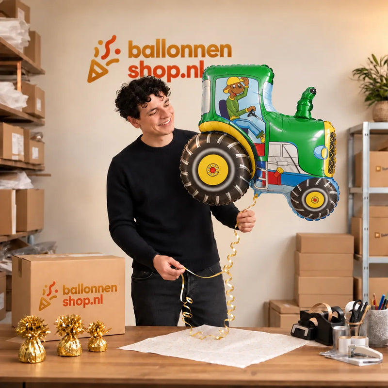 Jesse houdt de Tractor Helium XL Ballon vast in de warme inpakruimte van Ballonnenshop.nl.