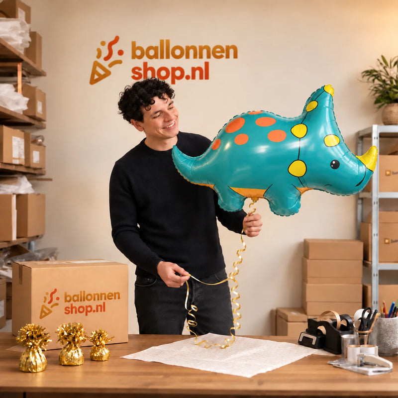 Jesse houdt de Triceratops Dino Helium XL Ballon vast in de warme inpakruimte van Ballonnenshop.nl.