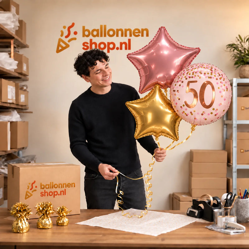 Jesse houdt het 50 Jaar Trosje Roze/Goud/Rose Goud vast in de warme werkplaats van Ballonnenshop.nl.