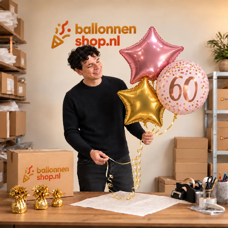 Jesse houdt 60 Jaar Trosje Roze/Goud/Rose Goud vast in de warme werkplaats van Ballonnenshop.nl.