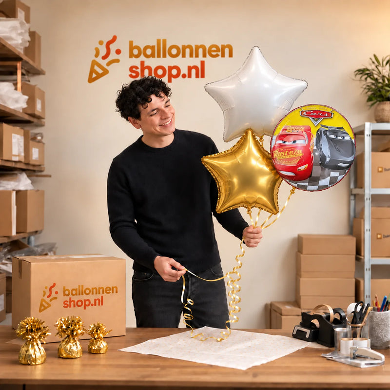 Jesse houdt Cars Trosje Goud/Wit/Rood vast in de warme werkplaats van Ballonnenshop.nl.