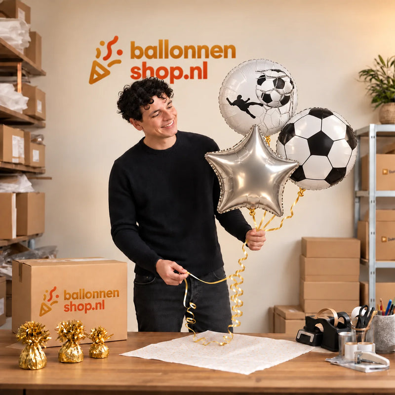 Jesse houdt Voetbal Trosje Zilver/Wit/Zwart vast in de warme werkplaats van Ballonnenshop.nl.