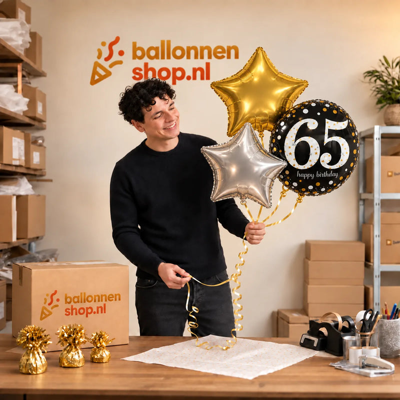 Jesse houdt 65 Jaar Trosje Zilver/Zwart/Goud vast in de warme werkplaats van Ballonnenshop.nl.
