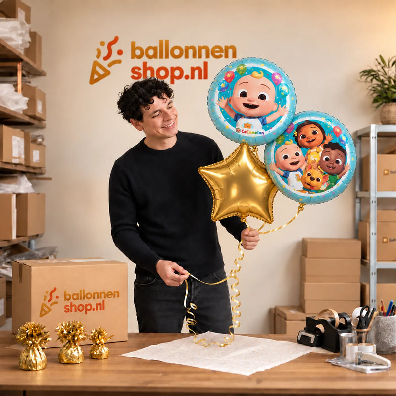 Jesse houdt Cocomelon Trosje Blauw/Wit/Goud vast in de warme werkplaats van Ballonnenshop.nl.