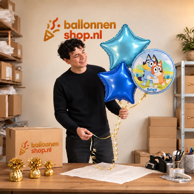Jesse houdt Bluey Trosje Blauw vast in de warme werkplaats van Ballonnenshop.nl.