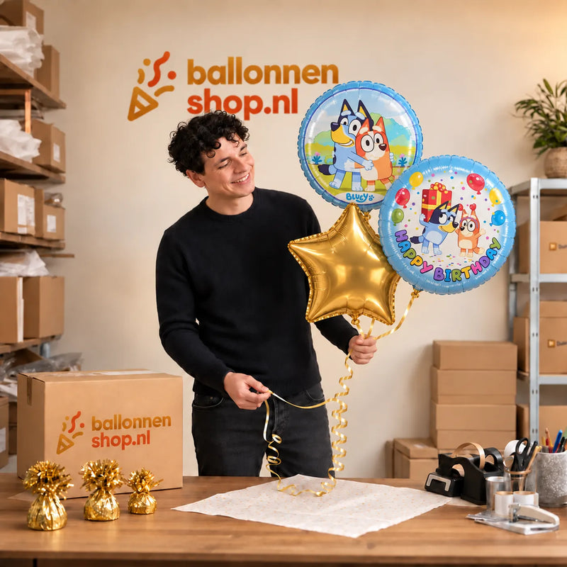 Jesse houdt Bluey Happy Birthday Trosje Blauw vast in de warme werkplaats van Ballonnenshop.nl.
