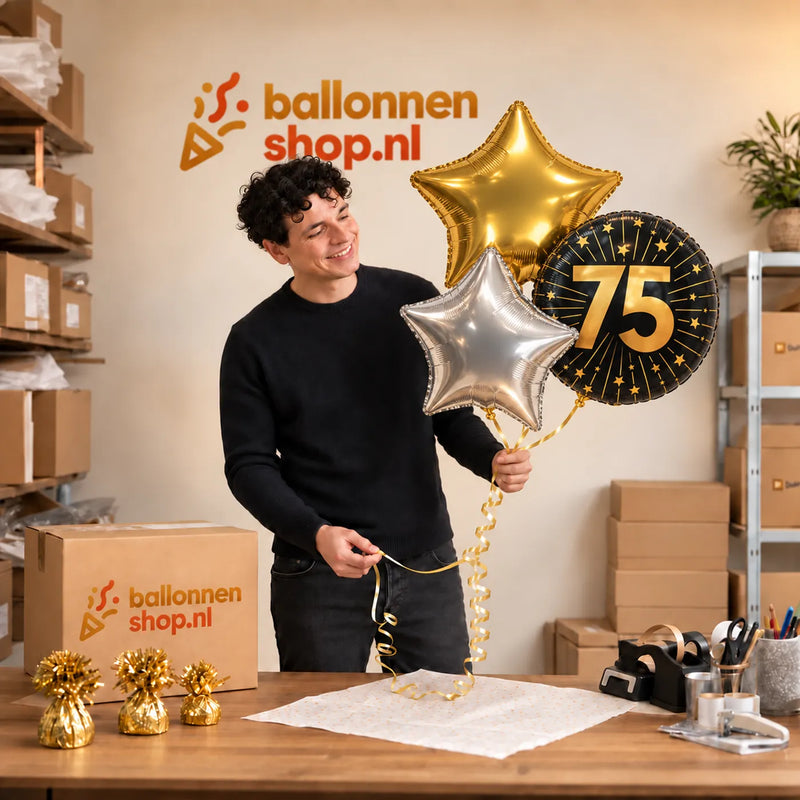 Jesse houdt 75 Jaar Trosje Zilver/Zwart/Goud vast in de warme werkplaats van Ballonnenshop.nl.