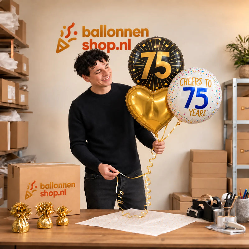 Jesse houdt 75 Jaar Trosje Goud/Zwart/Wit vast in de warme werkplaats van Ballonnenshop.nl.