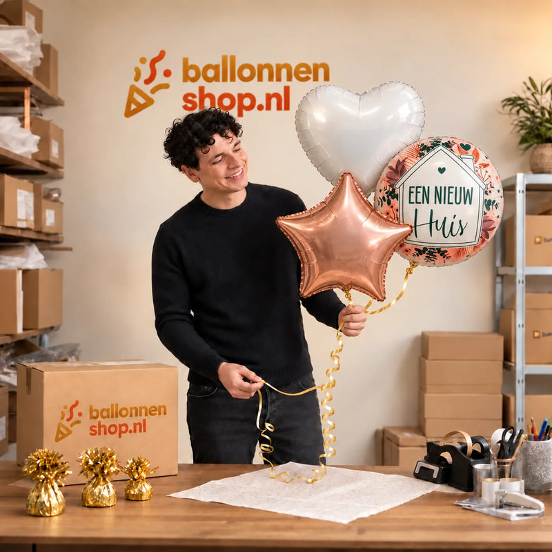 Jesse houdt Een nieuw Huis Trosje Ballonnen vast in de warme werkplaats van Ballonnenshop.nl.