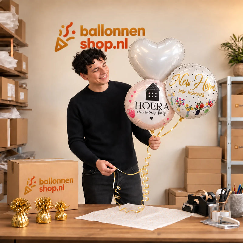 Jesse houdt Hoera Een nieuw Huis Trosje vast in de warme werkplaats van Ballonnenshop.nl.