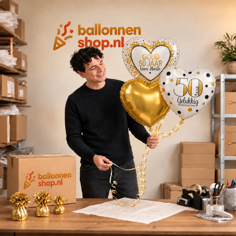 Jesse houdt 50 Jaar Getrouwd Trosje Goud vast in de warme werkplaats van Ballonnenshop.nl.