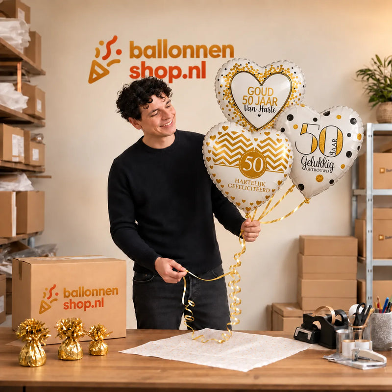 Jesse houdt 50 Jarig Huwelijk Trosje Goud vast in de warme werkplaats van Ballonnenshop.nl.