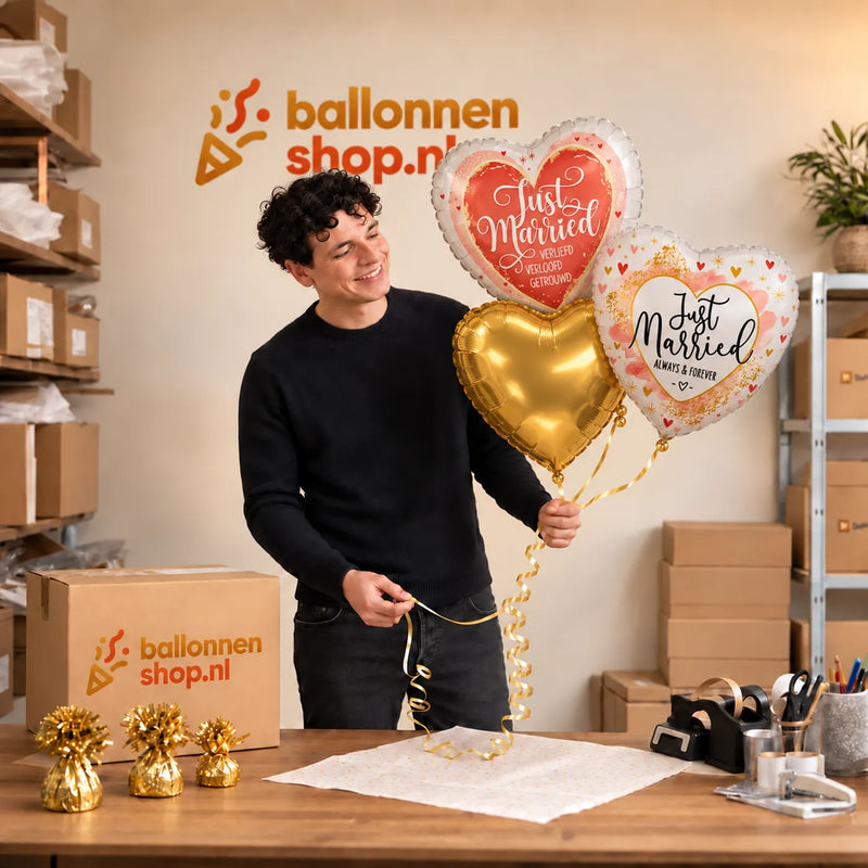 Jesse houdt Just Married Trosje Ballonnen vast in de warme werkplaats van Ballonnenshop.nl.