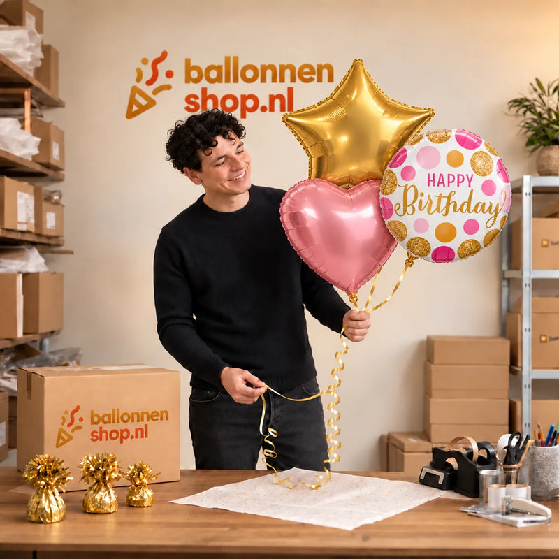 Jesse houdt Happy Birthday Roze/Goud/Wit Tros vast in de warme werkplaats van Ballonnenshop.nl.