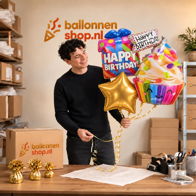Jesse houdt Happy Birthday XL Tros vast in de warme werkplaats van Ballonnenshop.nl.