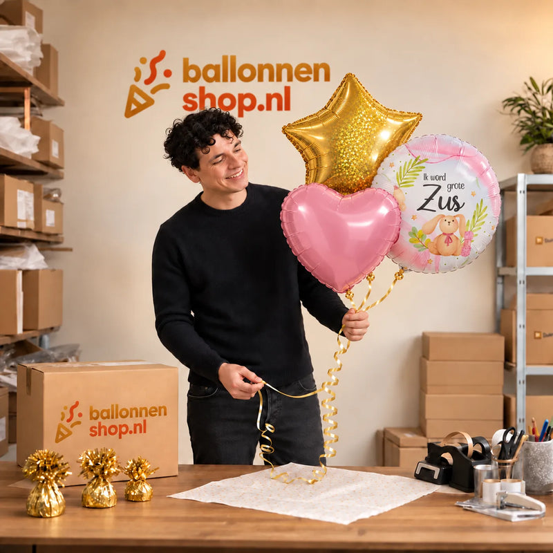 Jesse houdt Ik Word Grote Zus Trosje vast in de warme werkplaats van Ballonnenshop.nl.