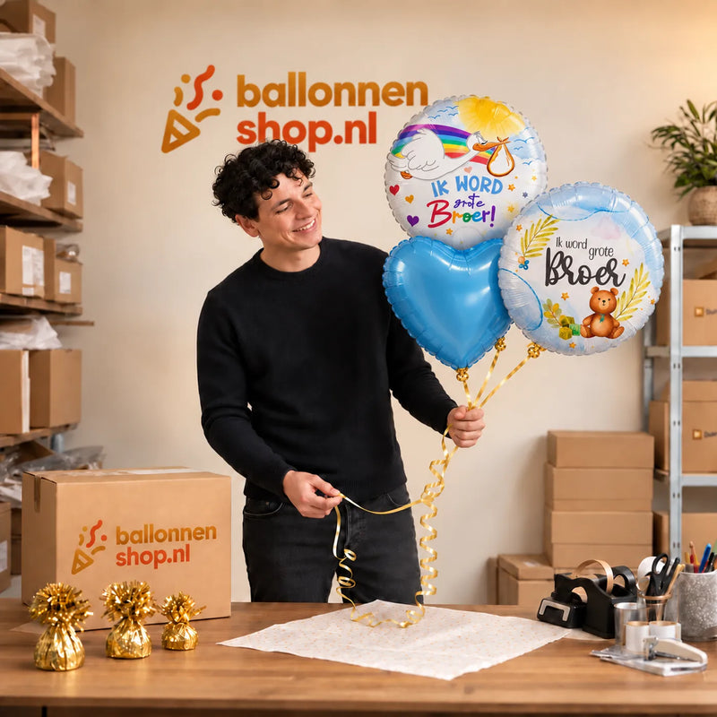 Jesse houdt Ik Word Grote Broer Trosje vast in de warme werkplaats van Ballonnenshop.nl.