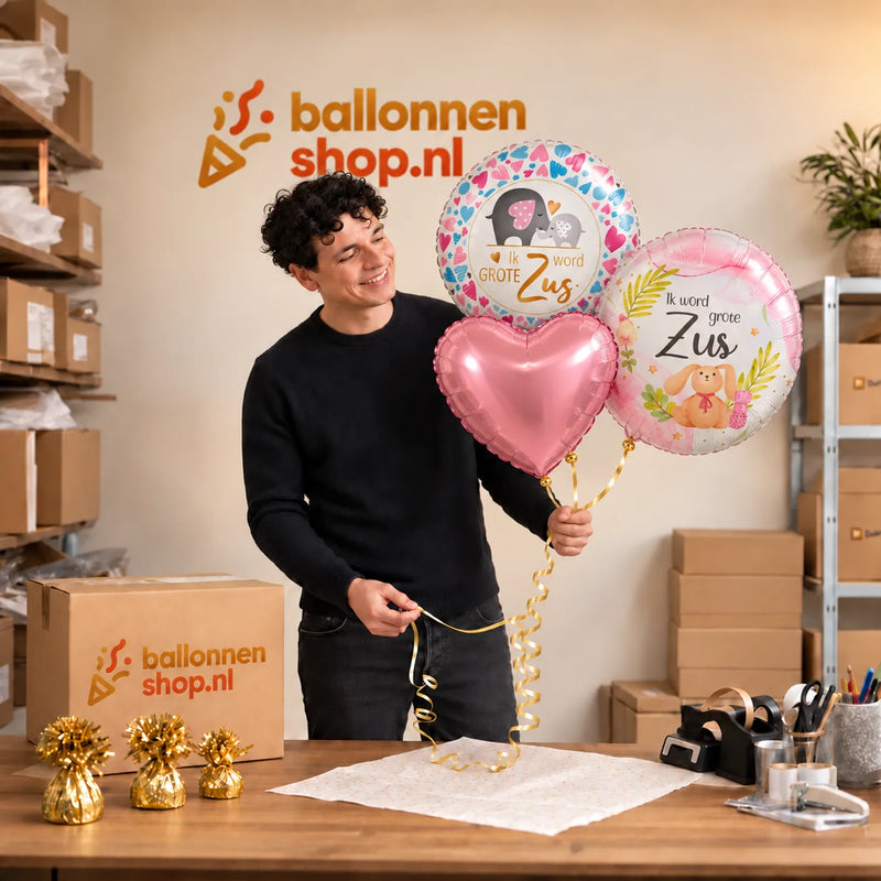 Jesse houdt Ik Word Grote Zus Trosje vast in de warme werkplaats van Ballonnenshop.nl.