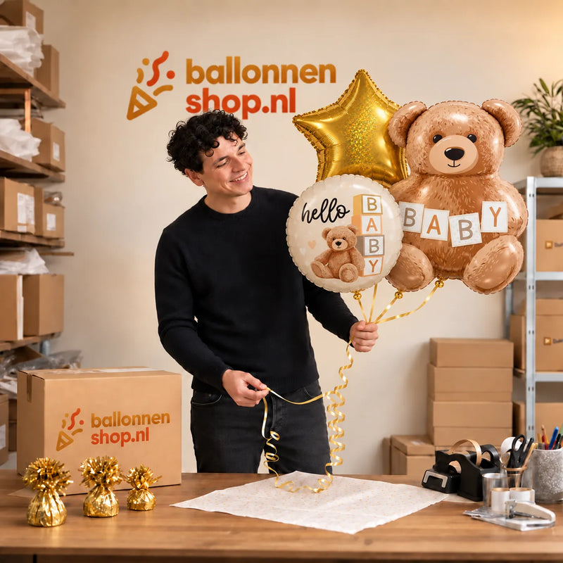 Jesse houdt Hello Baby Trosje Ballonnen vast in de warme werkplaats van Ballonnenshop.nl.