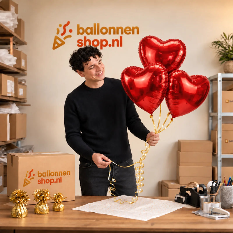 Jesse houdt Ballonnentros 3 Rode Hartjes – Een Warm Gebaar vast in de warme werkplaats van Ballonnenshop.nl.