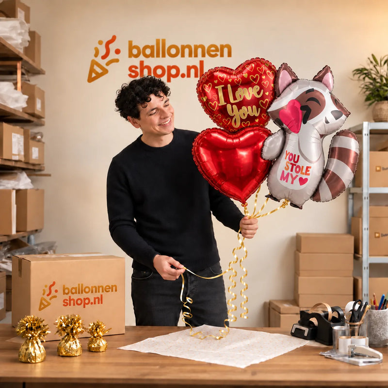 Jesse houdt You Stole My Heart Ballonnentros vast in de warme werkplaats van Ballonnenshop.nl.