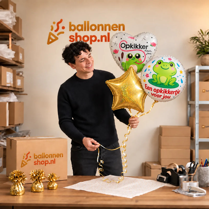 Jesse houdt Opkikker Voor Jou Trosje vast in de warme werkplaats van Ballonnenshop.nl.