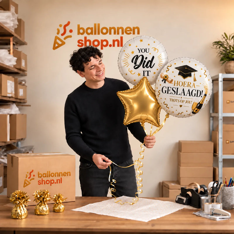 Jesse houdt Hoera Geslaagd Ballonnentros - Gevuld Met Helium - 45 cm vast in de warme werkplaats van Ballonnenshop.nl.