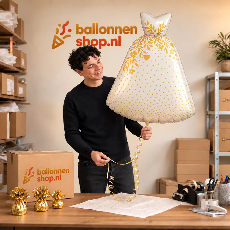 Jesse houdt de Trouwjurk Helium XL Ballon vast in de warme inpakruimte van Ballonnenshop.nl.