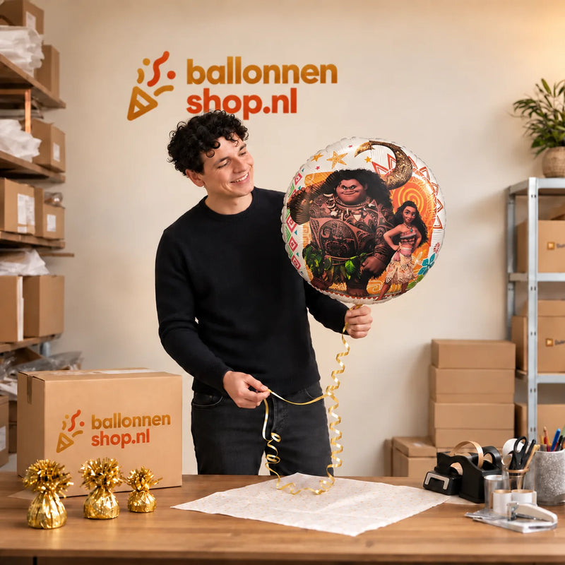 Jesse houdt de Vaiana En Maui Helium Ballon vast in de warme inpakruimte van Ballonnenshop.nl.