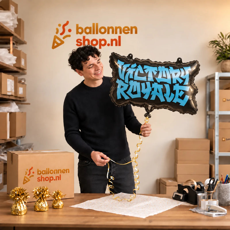 Jesse houdt de Victory Royale Helium Ballon vast in de warme inpakruimte van Ballonnenshop.nl.