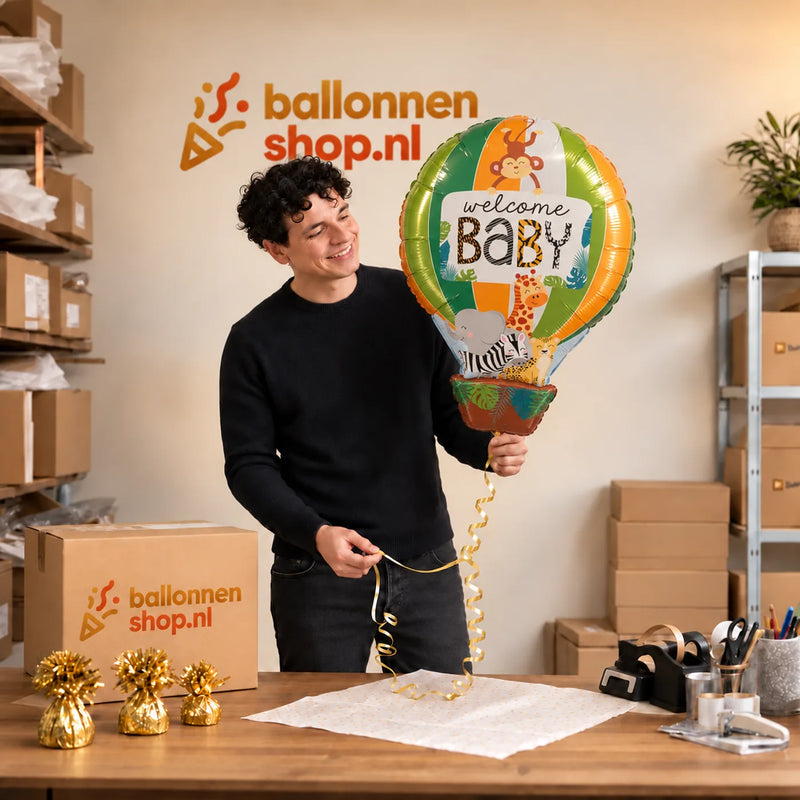 Jesse houdt de Welcome Baby Luchtballon Ballon vast in de warme inpakruimte van Ballonnenshop.nl.