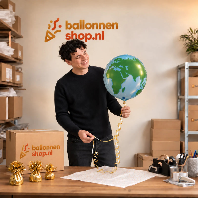 Jesse houdt de Wereldbol Helium Ballon vast in de warme inpakruimte van Ballonnenshop.nl.