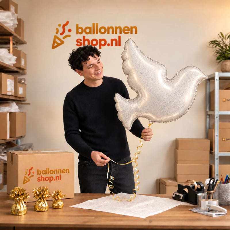 Jesse houdt de Witte Duif Helium XL Ballon vast in de warme inpakruimte van Ballonnenshop.nl.
