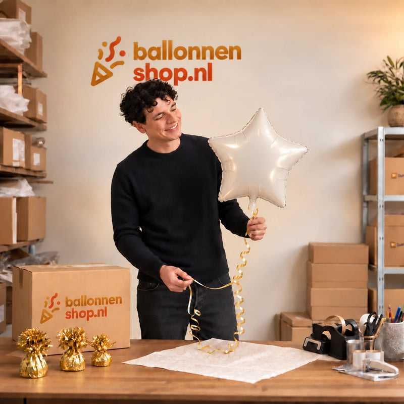 Jesse houdt de Witte Ster Helium Ballon vast in de warme inpakruimte van Ballonnenshop.nl.