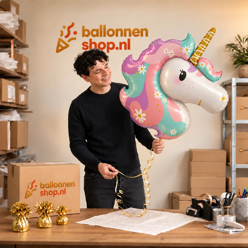 Jesse houdt de Unicorn Helium XL Ballon vast in de warme inpakruimte van Ballonnenshop.nl.