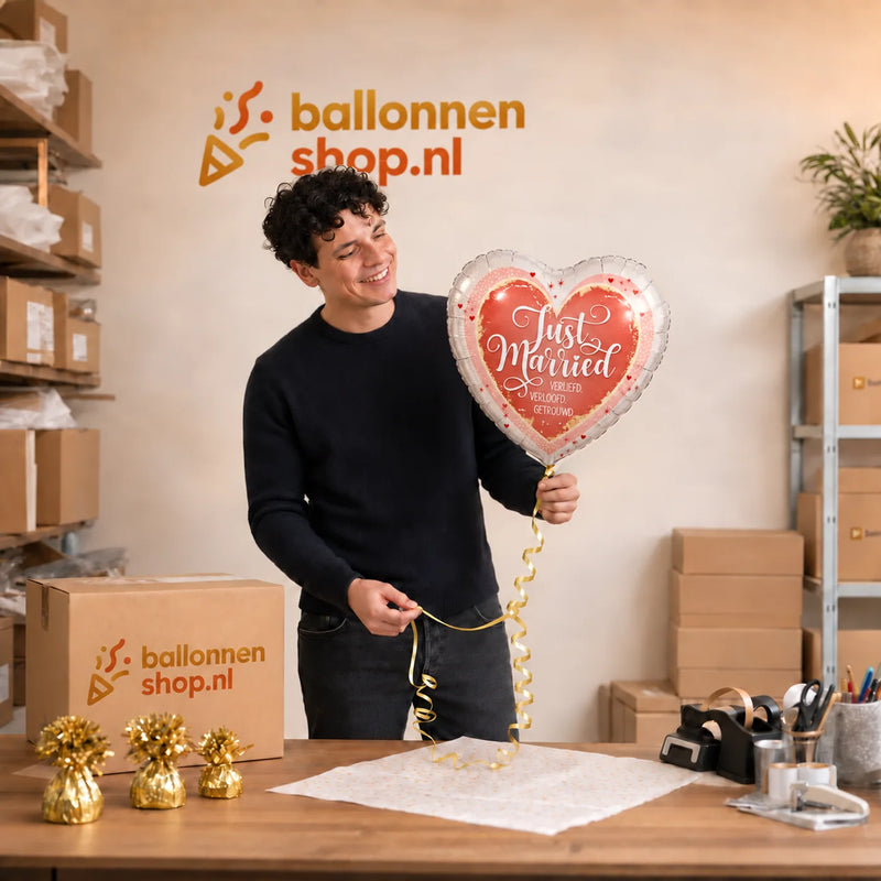Jesse houdt de Verliefd, Verloofd, Getrouwd vast in de warme werkplaats van Ballonnenshop.nl.