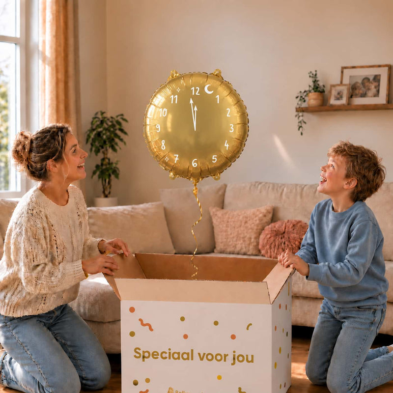 Moeder en zoon openen een cadeaudoos met een gouden klokballon van 45 cm met witte cijfers.
