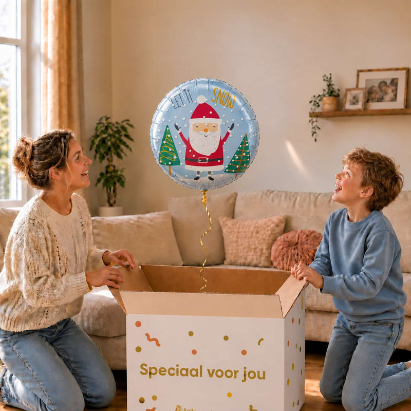 Moeder en jongetje pakken een Let It Snow kerstmanballon van 46 cm uit een cadeaudoos.