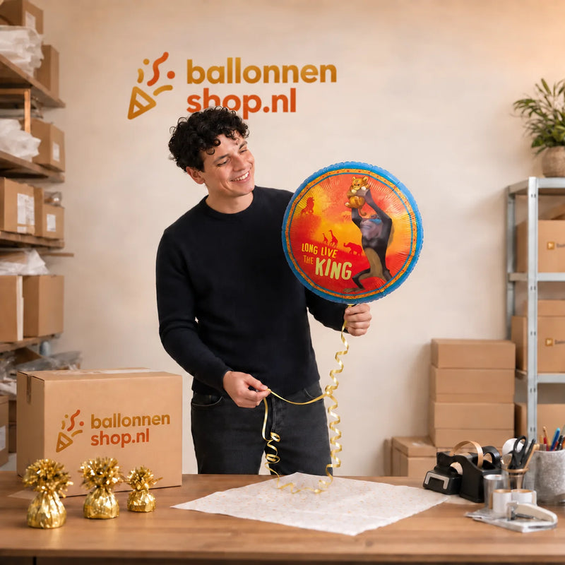 Jesse houdt de Long Live The King Lion King vast in de warme werkplaats van Ballonnenshop.nl.